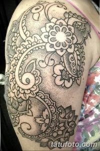 Фото тату хной на плече: сложный восточный узор в стиле мехенди, покрывающий плечо и часть руки. Идеально для создания яркого и запоминающегося образа.